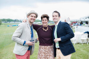 Three well-dressed people pose for a photo at the Foxfield Races
